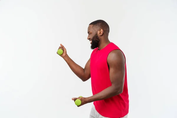 Fiatal afro-amerikai sportoló Holding feloldása súlyzók az elszigetelt fehér háttér. — Stock Fotó