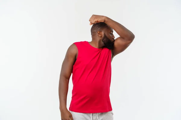 Afroamerikanska tonåringen visar musklerna på arm. Isolerade på vit bakgrund. Studio porträtt. Övergångsperiod ålder koncept — Stockfoto