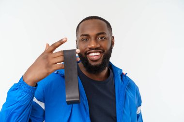 Kas siyah genç adam stüdyoda elastik bantları ile egzersiz, beyaz izole.