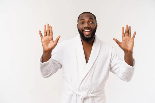 Pria kulit hitam mengenakan jubah mandi menunjuk jari dengan kejutan dan emosi bahagia. Terisolasi di atas latar belakang whtie . — Stok Foto