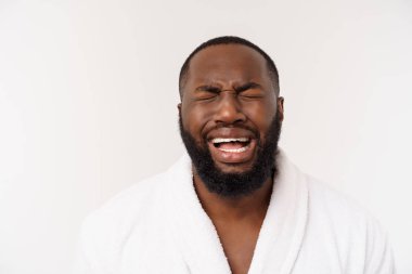 Genç African American Man izole beyaz arka plan üzerinde bornoz giyiyor yorgun görünümlü ve depresyon sorunları ile sıkılmış.