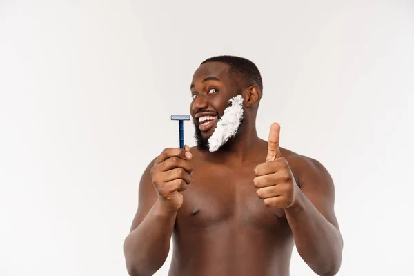 Νέος αφροαμερικανός άνθρωπος ξύρισμα στο μπάνιο. Προσωπική πρωινή ρουτίνα. Υγιεινή στο πρωινό concept. — Φωτογραφία Αρχείου