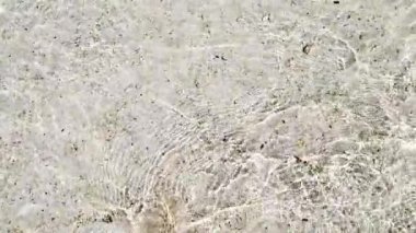 Su yüzeyi dokusu, yavaş çekim döngüsü temiz yüzme havuzu dalgaları ve dalgalar, güneş ışığının yansıması deniz kenarındaki beyaz kum..