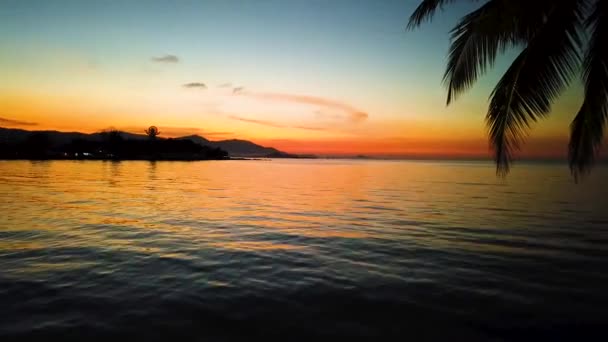 Zeitlupe der Meeresoberfläche mit kleinen Wellen vor dem Hintergrund des Sonnenaufgangs der Sonne. Goldenes Licht des Meerpanoramas — Stockvideo