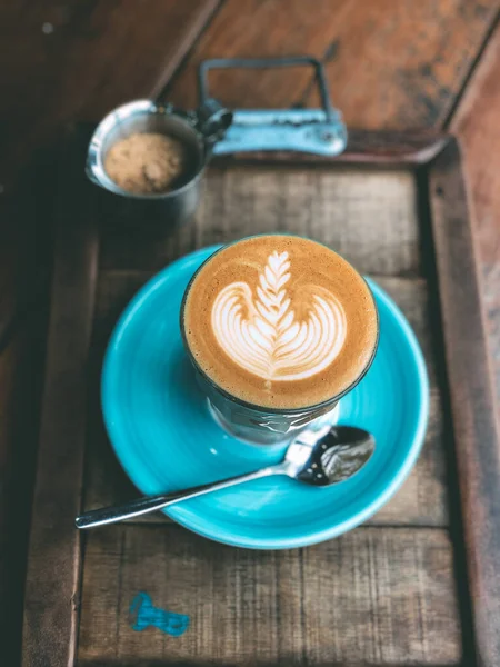 Filiżanka gorącej kawy sztuki latte na zabytkowym drewnianym stole. — Zdjęcie stockowe