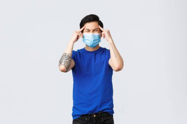 Farklı duygular, sosyal mesafeler, covid-19 'da kendini karantina ve yaşam tarzı konsepti. Sorunlu ve sıkıntılı genç adam çözüm bulmaya çalışıyor, beyin fırtınası yapıyor, kafa kafaya verip gözlerini kısıyor, düşünüyor.