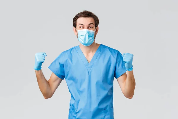 コロナウイルスの発生、病気と戦う医療従事者、病院の概念。スクラブ、医療用マスクや手袋、拳ポンプで幸せな医師は、偉大なニュースを祝う、はい、達成または突破口を叫ぶ — ストック写真