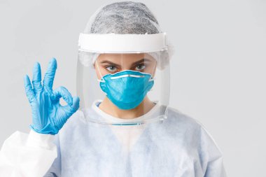 Covid-19, virüsün önlenmesi, sağlık, sağlık çalışanları ve karantina konsepti. Kişisel koruyucu ekipman, lastik eldiven giymiş kadın doktor ya da hemşireye yakın çekim, tamam, garantili ya da garantili
