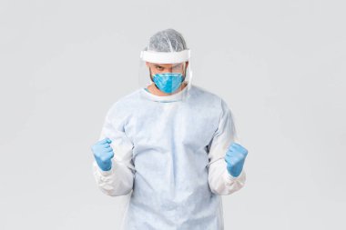 Covid-19 salgını, virüs salgını, klinik ve sağlık çalışanları konsepti. Kendine güveni tam bir doktor koruyucu ekipman, kendine güveni arttırma yumruk pompası, koronavirüsle mücadele.