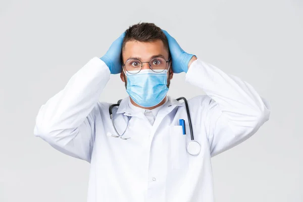 Covid-19，保健工作者，大流行病和预防病毒概念。有关方面和焦虑的特写镜头，神经质的医生戴着医疗面罩和白衣，抓着头喘气，目瞪口呆 — 图库照片