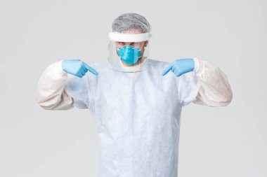 Covid-19, salgın hastalık, virüs salgınıyla mücadele eden sağlık çalışanları. Kendine güvenen, tıbbi maskeli, lastik eldivenli ve kendini gösteren koruyucu ekipmanlı genç bir doktor hastaların hayatını kurtarıyor.