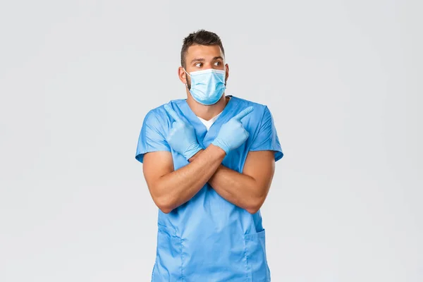 医療従事者, covid-19,コロナウイルスやウイルスの概念を防止.興味をそそり、優柔不断なハンサムな医者、頭蓋骨と医療用マスクの男性看護師は、バナーを横に指して選択を行います — ストック写真