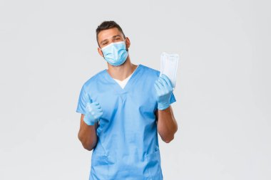 Sağlık çalışanları, covid-19, koronavirüs ve virüs konseptini önlemek. Yakışıklı erkek doktor, önlüklü hemşire ve kişisel koruyucu ekipman, tıbbi maske ve baş parmağını kaldırma