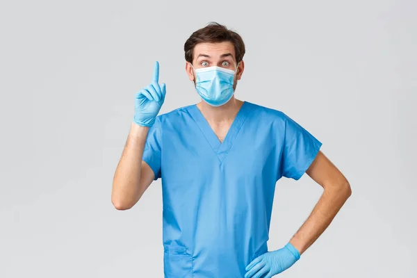 コロナウイルスの発生、病気と戦う医療従事者、病院の概念。医療用マスク、スクラブ、手袋のスマートかつ創造的な医師は、アイデアを持っています、指を上げるeureka 、提案を追加 — ストック写真