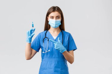 Covid-19, virüsün önlenmesi, sağlık, sağlık çalışanları ve karantina konsepti. Mavi önlüklü, tıbbi maskeli, Coronavirus aşısı olan ciddi bir kadın hemşire ya da doktor.