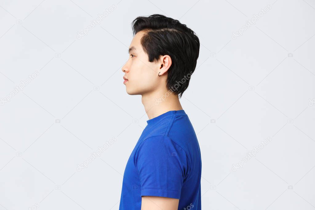 Lifestyle, people emotions and beauty concept. Profile portrait of stylish good-looking asian hipster, queer guy with earring, new haircut from barbershop, look normal expression left