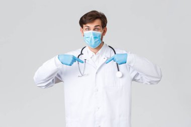 Hastane, sağlık çalışanları, covid-19 tedavi konsepti. Acil bir durumda doktoruna danış. Beyaz önlüklü doktor, tıbbi maske ve eldivenler kendini gösteriyor, hastayla konuşuyor.