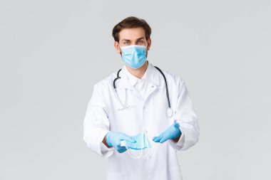 Hastane, sağlık çalışanları, covid-19 tedavi konsepti. Kişisel koruyucu ekipman ve önlük doktoru, elinde tıbbi maskeler, Coronavirus sırasında hastaların sağlığını koruma yöntemlerini gösteriyor.
