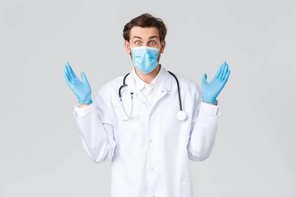 Hospital, trabajadores sanitarios, concepto de tratamiento covid-19. Médico con problemas tienen un montón de pacientes, médico que comping con el trabajo de estrés, el uso de exfoliantes, guantes y máscara médica, fondo gris —  Fotos de Stock