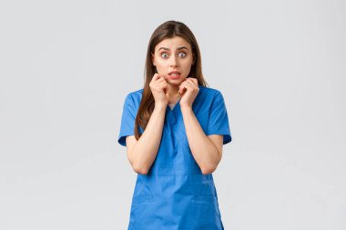 Sağlık çalışanları, virüsü, sigortayı ve ilaç konseptini engelleyin. Endişeli ve korkmuş kadın hemşire kötü bir dedikodu ya da şok edici bir dedikodu duyar, titrer, endişeli görünür, el ele tutuşur.