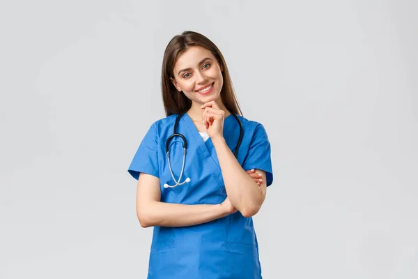 Pracownicy medyczni, opieka zdrowotna, koncepcja covid-19 i szczepień. Upbeat uśmiechnięta ładna pielęgniarka, lekarz w niebieskim fartuchu, klinika pracy, patrząc z entuzjastycznym aparatem wzrokowym, słuchając współpracownika — Zdjęcie stockowe