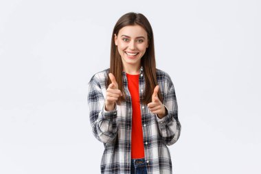 Yaşam tarzı, farklı duygular, boş zaman aktiviteleri konsepti. Hevesli ve mutlu, sıradan kıyafetli genç bir kız kamerayı işaret ediyor, anladım ya da tebrik ediyorum, seni seçiyor.