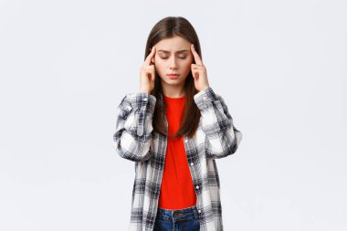 Yaşam tarzı, farklı duygular, boş zaman aktiviteleri konsepti. Odaklanmaya çalışan üzgün ve yorgun genç kız öğrenci baş ağrısı ya da baş dönmesi hisset, gözlerini kapat ve tapınakları ovala, beyaz arka plan