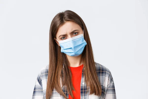 Surto de coronavírus, lazer em quarentena, distanciamento social e conceito de emoções. Close-up de mulher com máscara médica sentindo-se mal, pegar doença ou estar cansado após o turno da noite — Fotografia de Stock