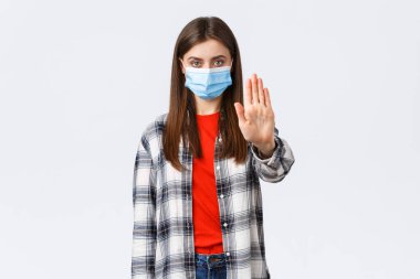 Coronavirus salgını, karantina, sosyal mesafeler ve duygu kavramı. Covid-19 yaymayı bırak. Evde kal. Ciddi genç kadın içki yasağı, kısıtlama veya uyarı konularında elini uzattı