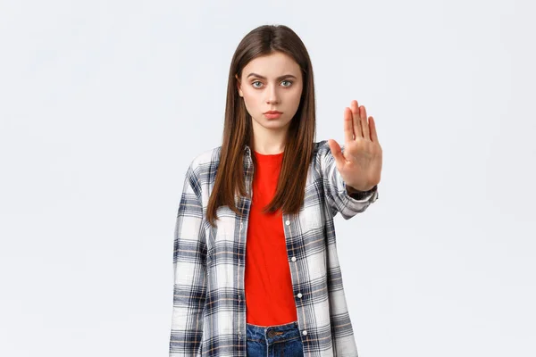 Estilo de vida, emociones diferentes, concepto de actividades de ocio. Es hora de parar. Mujer joven seria en traje casual, estirar la mano hacia adelante para prohibir, restringir o prohibir algo, fondo blanco —  Fotos de Stock