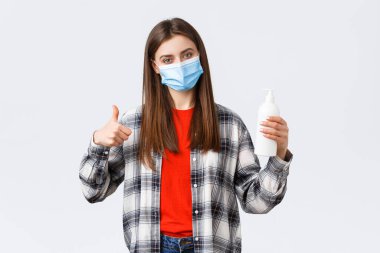 Coronavirus salgını, karantina, sosyal mesafeler ve duygu kavramı. Tatmin olmuş kadın müşteri, tıbbi maske takan müşteri bu el sabunu ya da el dezenfektanı, baş parmak yukarı.
