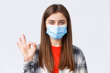Coronavirus salgını, karantina, sosyal mesafeler ve duygu kavramı. Tıbbi maskeli güzel bir kadının yakın plan çekimleri, her şeyin yolunda olduğuna emin olun, tamam mı?
