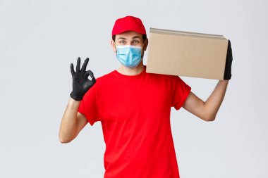 Paketler ve paket teslimatı, karantina teslimatı, nakil emirleri. Kurye teslimatı, omuz hizasında tutulan kutu, tamam işareti yap, sorun yok, güvenli satın alma ve nakliye garantisi