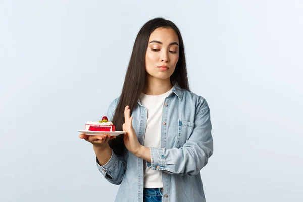 Social distanciamiento estilo de vida, covid-19 pandemia, celebrando las fiestas durante el concepto coronavirus. renuente arrogante asiático chica tomando cuidado de cuerpo, rechazando el postre, poco dispuesto comer pastel de cumpleaños — Foto de Stock