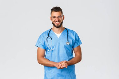 Sağlık çalışanları, ilaç, covid-19 ve salgın kendini karantina konsepti. Neşeli, gülümseyen İspanyol erkek hemşire, acil serviste doktor önlük ve gözlük takıyor, klinikte hastayla konuşuyor.