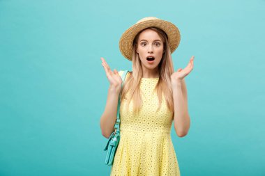 Şok ya da İyi Haber Konsepti: Uzun saçlı, uzun saçlı sarışın kız izole edilmiş mavi arka planda duruyor. Şaşkınlıkla ağzını açtı..