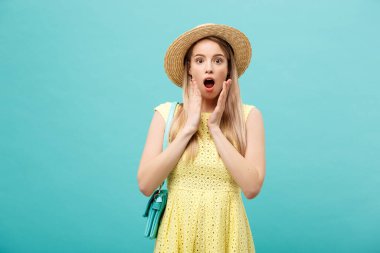 Şok ya da İyi Haber Konsepti: Uzun saçlı, uzun saçlı sarışın kız izole edilmiş mavi arka planda duruyor. Şaşkınlıkla ağzını açtı..