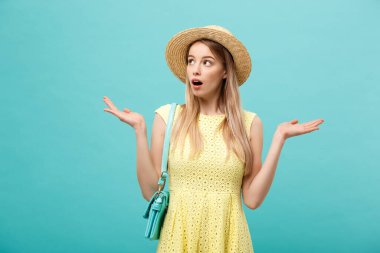 Şok ya da İyi Haber Konsepti: Uzun saçlı, uzun saçlı sarışın kız izole edilmiş mavi arka planda duruyor. Şaşkınlıkla ağzını açtı..