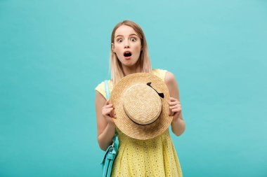 Şok ya da İyi Haber Konsepti: Uzun saçlı, uzun saçlı sarışın kız izole edilmiş mavi arka planda duruyor. Şaşkınlıkla ağzını açtı..