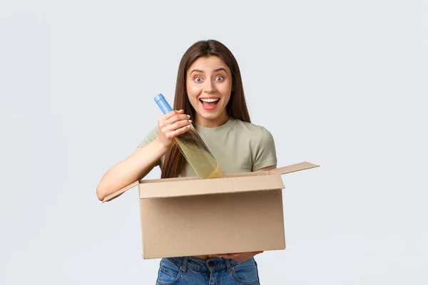 Entrega a domicilio en línea, pedidos por Internet y concepto de compras de comestibles. Mujer emocionada pidió comestibles en la tienda de Internet, la celebración de la caja de comida para llevar botella de vino y sonriendo divertido —  Fotos de Stock