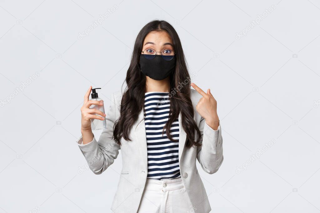 Business, finance and employment, covid-19 preventing virus and social distancing concept. Cute asian office lady explain importance of wearing face masks and use hand sanitizers during pandemic