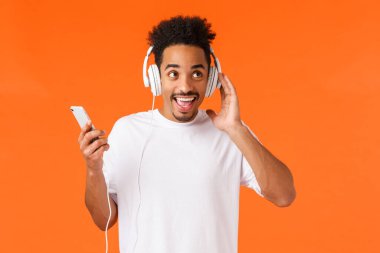 Karizmatik heyecanlı, mutlu, Afro saçlı, bıyıklı, kulaklıklı müzikten hoşlanan kulaklıklı, kulaklıklı, kulaklıklı, akıllı telefonlu, favori müziğini dinleyen, yeni bekar,
