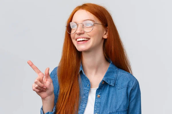 Close-up dromerig en vrolijk, opgewonden roodharige vrouw in bril, dromen over toekomstige kansen, streven naar de beroemde universiteit, wijzen en kijken linksboven gelukkig — Stockfoto