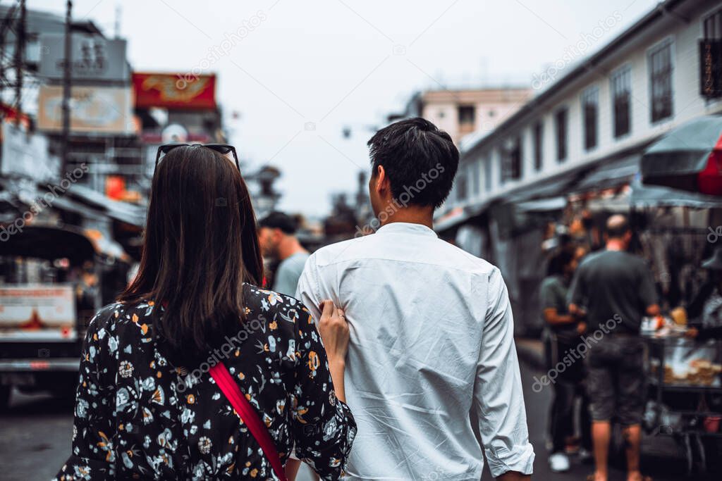 Back view of young couple enjoy walking at Khaosan Road, Bangkok.