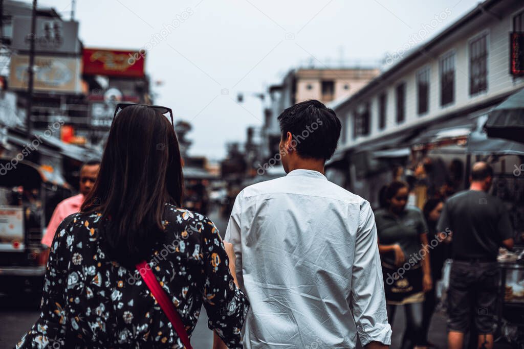 Back view of young couple enjoy walking at Khaosan Road, Bangkok.