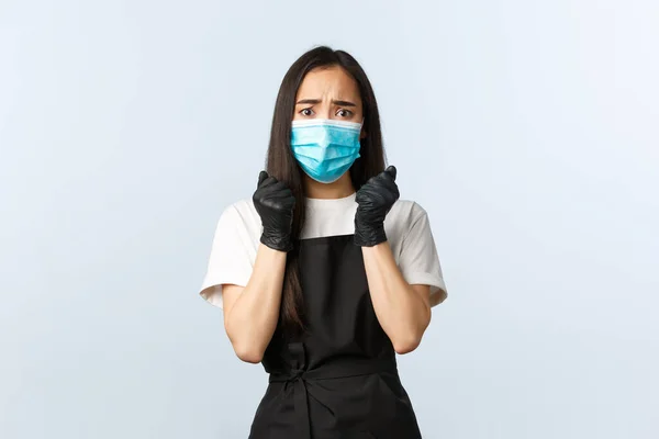 Covid-19-Pandemie, soziale Distanzierung, Kleinunternehmen und Virusprävention. Besorgte asiatische Barista hat Angst vor Husten während des Coronavirus-Ausbruchs, trägt medizinische Maske und Handschuhe — Stockfoto