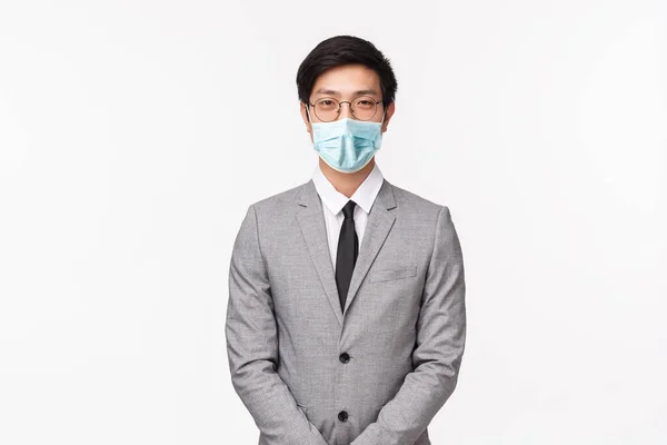 Affärs-, finans- och karriärkoncept. Porträtt av professionell stilig ung asiatisk man i grå kostym och slips, ser bestämd kamera, artigt leende, träffa kompanjoner, vit bakgrund — Stockfoto