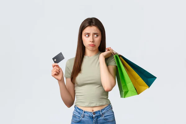 쇼핑 센터, 생활 방식, 패션 컨셉. 무표정하고 슬프고 귀여운 얼굴을 한 여자가 빈 신용 카드를 가지고 불평하는 모습, 어깨 위에 가방을 들고 있는 것처럼 똑바로 실망해 보이는 모습 — 스톡 사진
