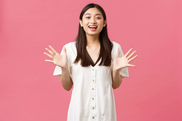 Beleza, emoções das pessoas e conceito de lazer de verão. Glamour animado menina asiática bonita descrever notícias impressionantes, gesto, levantar as mãos e sorrir como dizer grande anúncio, fundo rosa — Fotografia de Stock