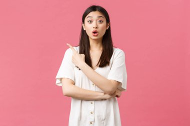 Güzellik, insan duyguları ve yaz tatili konsepti. Şaşırmış ve etkilenmiş, aptal Asyalı elbiseli, makyajlı, sol üst köşesinde, tanıtım hakkında sorular soran,